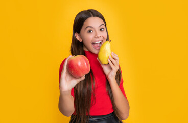 cheerful amazed child hold fresh apple and pear on yellow background. selective focus