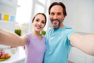 Fototapeta premium Photo of two positive friendly partners make selfie recording video toothy smile house indoors