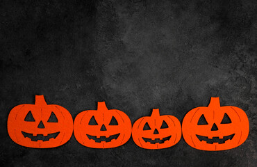 Halloween flat lay with felt pumpinks in black concrete background.Banner with place for text.