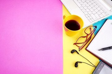 Top view of colorful working table have Headphones,mobile phone and cup of tea on color blue, Yellow and pink background for create idea for business or design. Relax time listen song (flat lay).
