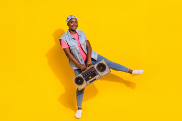 Fototapeta Full length portrait of excited overjoyed girl hold vintage boom box isolated on yellow color background obraz