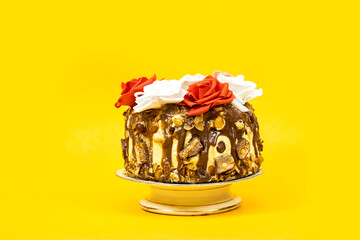 Birthday layer cake decorated with chocolate pieces and hazelnuts and almonds and hazelnuts and...