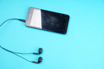 Obraz premium Top view of Mobile phone with headphones isolated on colorful background, Listen to music. Space for text