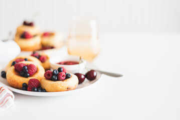 Homemade cottage cheese pancakes with fresh berries on white table
