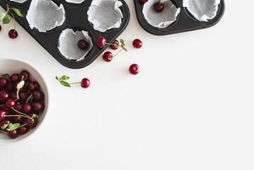 Cooking homemade cherry muffins with fresh berries on white wooden table. Top view