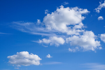 Fototapeta na wymiar White fluffy clouds in the blue bright sky