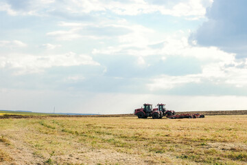 Fototapeta premium Combine harvester on the field of wheat. Perfect summer view from flying drone of harvesting wheat on sunset. Picturesque rural scene in Ukraine, Europe.