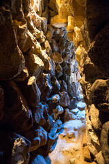 Dark tunnel in stone cave with exit light