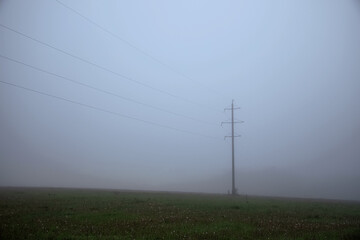 Fototapeta na wymiar The power line is in the fog. Electrification. High voltage. A mystical place.