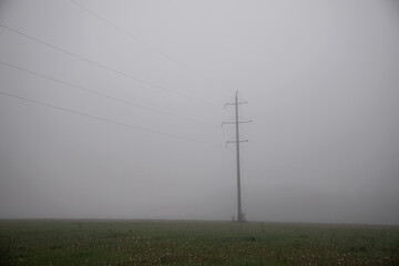 The power line is in the fog. Electrification. High voltage. A mystical place.