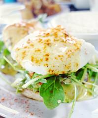 Eggs Benedict with fresh baby spinach greens and paprika
