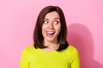 Portrait of excited lovely lady tongue lick teeth look interested empty space isolated on pink color background