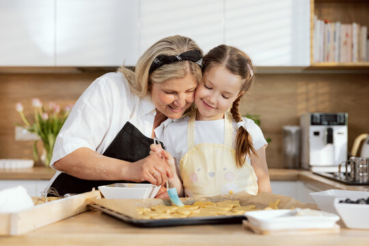 Delighted eldest granny teaching grandkid preparing dough for cookies. Baking cooking homemade biscuits cookies