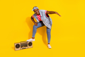 Full length portrait of cheerful carefree person put leg vintage boombox isolated on yellow color background