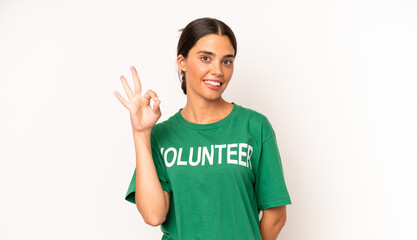 pretty hispanic woman feeling happy, showing approval with okay gesture. ecology and volunteer...