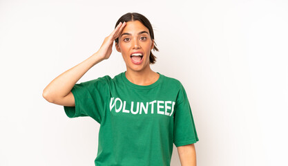 pretty hispanic woman looking happy, astonished and surprised. ecology and volunteer concept