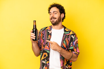 crazy bearded man smiling cheerfully, feeling happy and pointing to the side. beer and vacations concept - obrazy, fototapety, plakaty