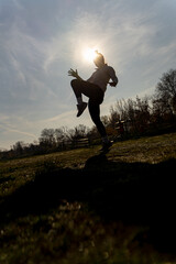Exercising kickbox, silhouette. Low angle. Sunlight