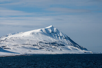 Views of the coast of Svalbard with mountains, ice and ocean in the sunshine
