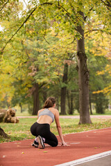 Preparing and focusing on the run and standing on the red track, in the park