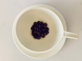 White cup of coffee with coffee beans 