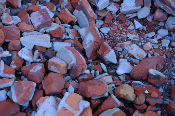 grey concrete stone with brocken red bricks on the background as a ruins of building backdrop