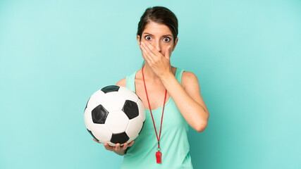 pretty caucasian woman covering mouth with hands with a shocked. soccer trainer concept