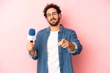crazy bearded man pointing at camera choosing you. presenter with a microphone concept