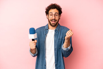 crazy bearded man feeling shocked,laughing and celebrating success. presenter with a microphone...