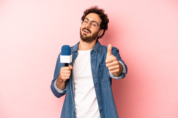 crazy bearded man feeling proud,smiling positively with thumbs up. presenter with a microphone...