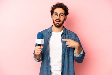 crazy bearded man feeling happy and pointing to self with an excited. presenter with a microphone...