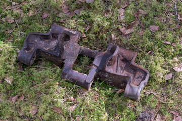 old rusty metal track link, caterpillar, from a tractor or tank, in the forest, dug out of the...
