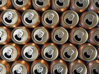 Empty open drink cans in golden color, top view background image