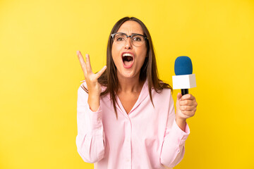 hispanic young adult woman looking desperate, frustrated and stressed. interviewer with a microphone