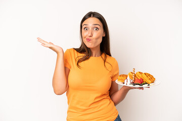 hispanic young adult woman feeling puzzled and confused and doubting. waffles breakfast concept