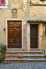 Fototapeta na wymiar Façade of an old building with wooden doors at the top of steps, Tuscany, Italy