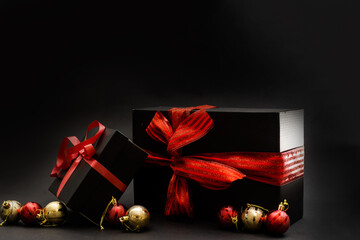 Fototapeta black gift box, balls, red Christmas decorations on the dark wooden background copy space obraz