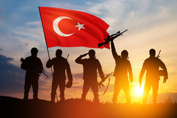 Silhouettes of soldiers with Turkey flag against the sunrise or sunset. Concept of crisis of war...