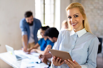 Portrait of happy successful business people working on tablet in office. Business teamwork concept