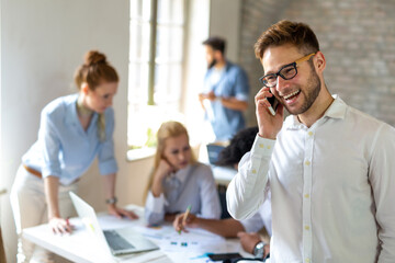 Working on new project together. Group of happy business people cooperating as a team in office