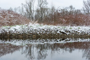 Bielsko-Biała, dopływ Wisły, wczesna wiosna, brzeg rzeki odbijający się w wodzie, śnieg, drzewa, woda (3). - obrazy, fototapety, plakaty