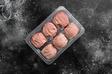 Plastic pack with meat and meatballs, on black dark stone table background, top view flat lay, with...