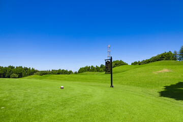 青空のゴルフ場・多数のコブがある難しいコースのティーインググラウンドと8番コースの案内板（千葉県木更津市） - obrazy, fototapety, plakaty