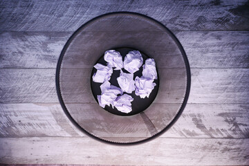 Obraz na płótnie Canvas crumpled paper ball in a bin top view 