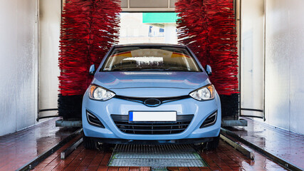 Car washing machine. Auto brush washer clean blue car on automatic carwash station. Automated car...