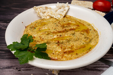 Bowl with homemade chickpea hummus on a rustic surface