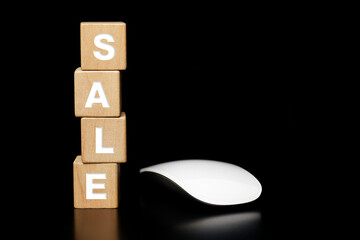 Wooden block with the word SALE and a mouse on a dark background. Business sales and discounts shop online concept.