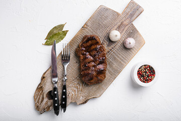 Sliced grilled beef barbecue Striploin steak, on white stone table background, top view flat lay, with copy space for text