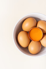 Whole eggs, egg yolk, and one broken isolated on a white background. Top view. Place for text.