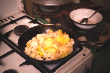 Fried potatoes in frying pan on gas stove